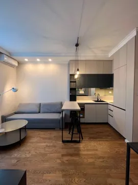 Modern living room with sofa and fitted kitchen. - image 3