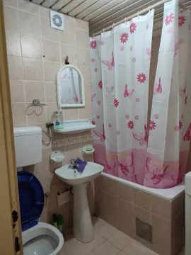 Simple bathroom with a bathtub, sink, and toilet. - image 10