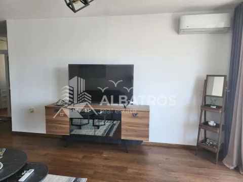 Dnevni boravak sa TV komodom i klima uređajem na zidu. - image 3