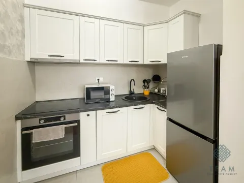 Compact white kitchen with built-in appliances and a refrigerator. - image 5