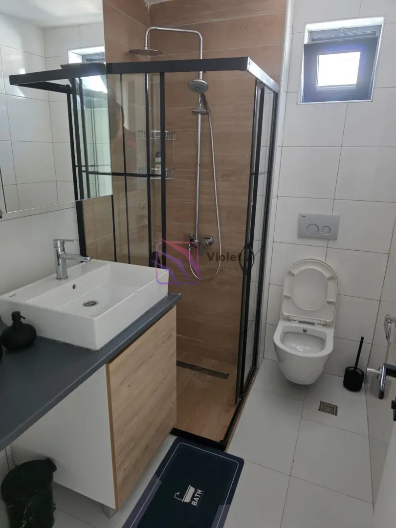 Moderno opremljeno kupatilo sa tuš kabinom, umivaonikom i wc šoljom.