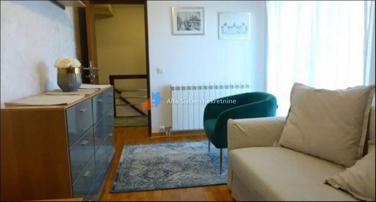 Living room with a sofa, armchair and chest of drawers.
