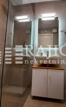 Modern bathroom with a sink, mirror, and walk-in shower. - image 11