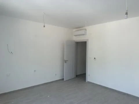 Prazna soba sa bijelim zidovima, klima uređajem i otvorenim vratima. - image 4