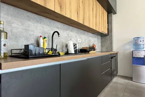 Modern kitchen with dark units and a wooden countertop. - image 7