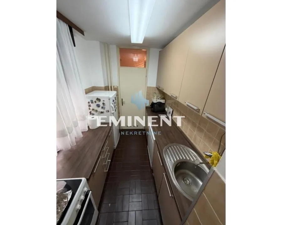 Smaller kitchen with cabinetry and sink.