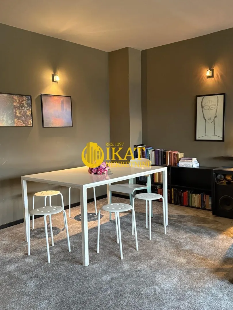 Living room with a dining table, chairs, and bookshelves.