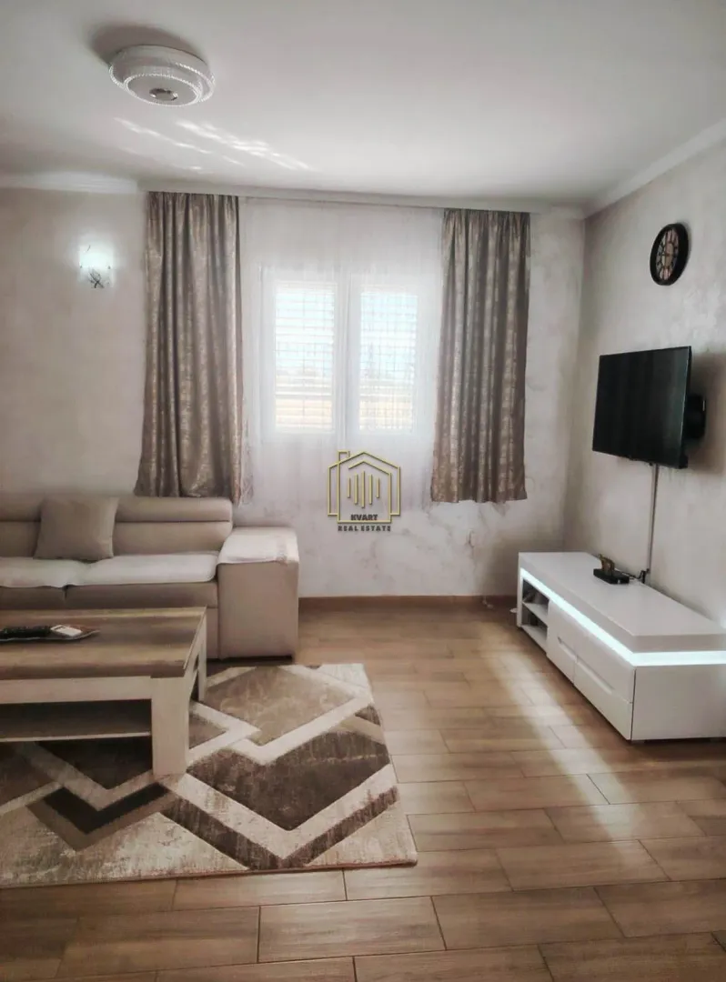 Living room with a sofa, coffee table, and TV unit.