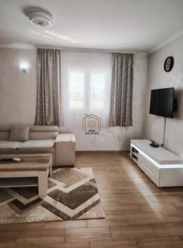 Living room with a sofa, coffee table, and TV unit. - image 2