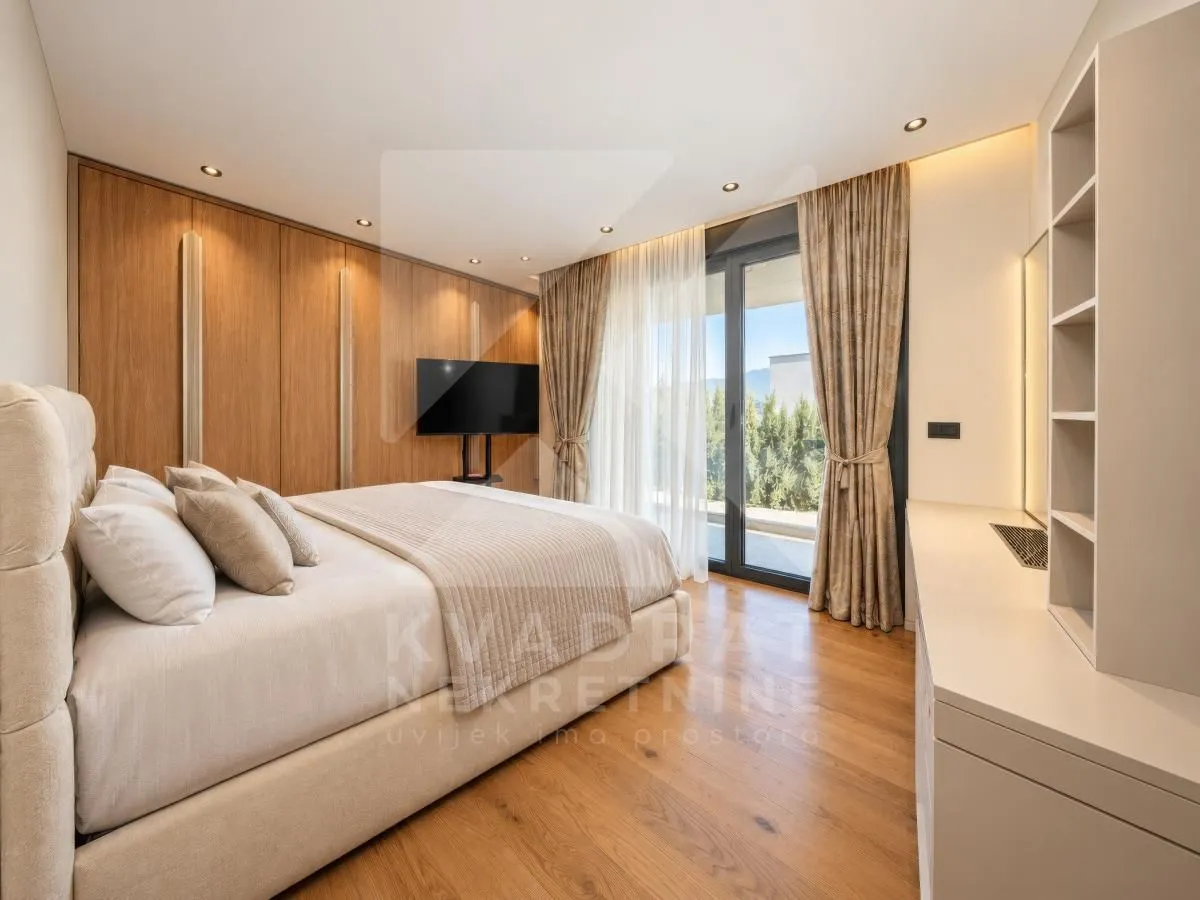 Modern bedroom with a double bed, wooden wall panels, and access to the terrace.