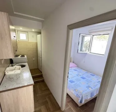 Small kitchen with a counter and a view of the bedroom. - image 4