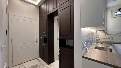 Small kitchen with dark built-in units and white doors. - image 4