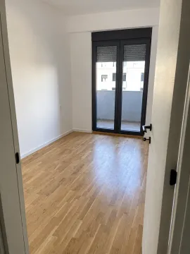 Prazna soba sa drvenim podom i izlazom na terasu. - image 3