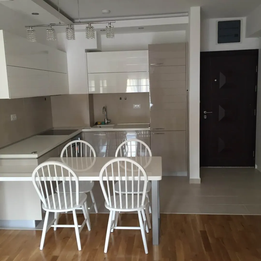 Modern kitchen with a dining table and white chairs.