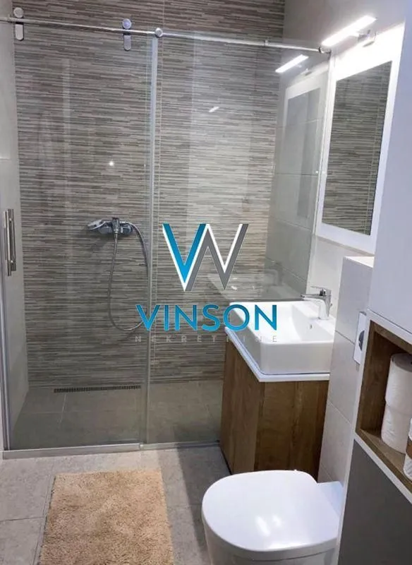 Moderno kupatilo sa tuš kabinom, umivaonikom i wc šoljom.