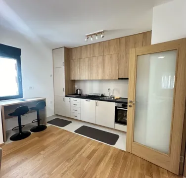 Modern kitchen with wooden elements and a dining bar. - image 3