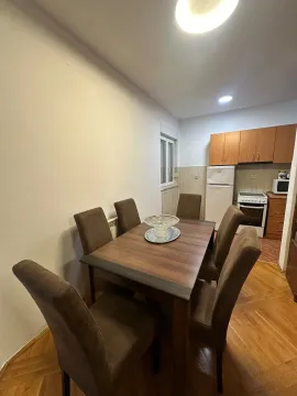 Dining area with a table and chairs and a view of a small kitchen. - image 5