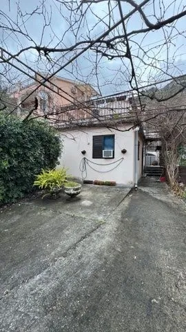 Eksterijer kuće sa dvorištem i lozom.