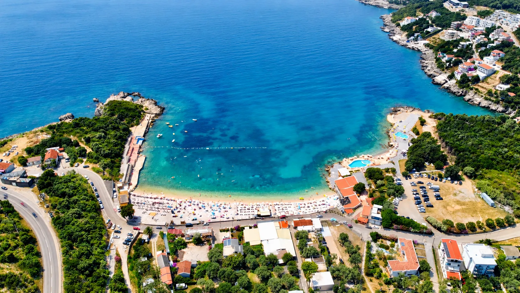 Pogled iz vazduha na uvale, plažu i okolno naselje.