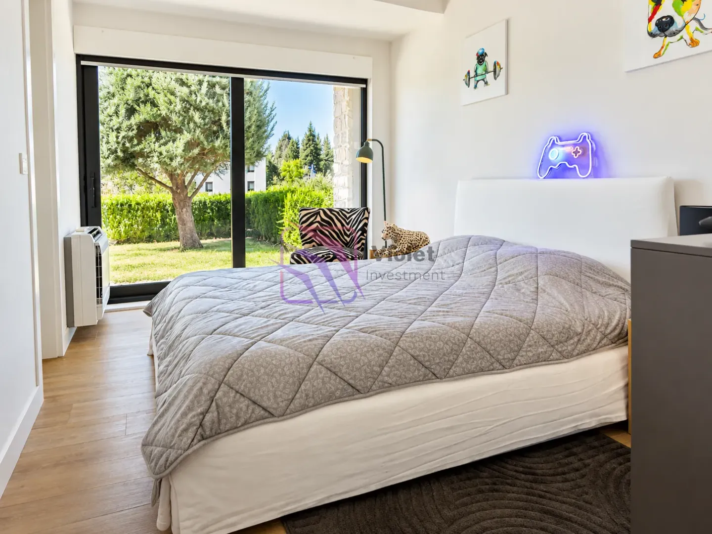 Bright bedroom with a large double bed and a view of the green courtyard.