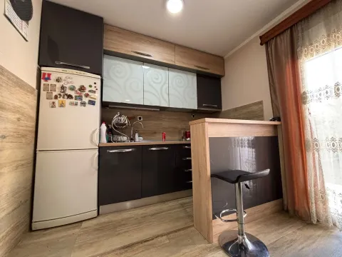 Small kitchen with dark and wood-finish cabinets and a breakfast bar. - image 7