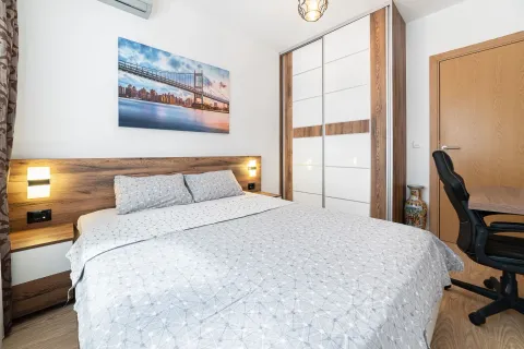 Furnished bedroom with a double bed, wardrobe, and a desk. - image 6