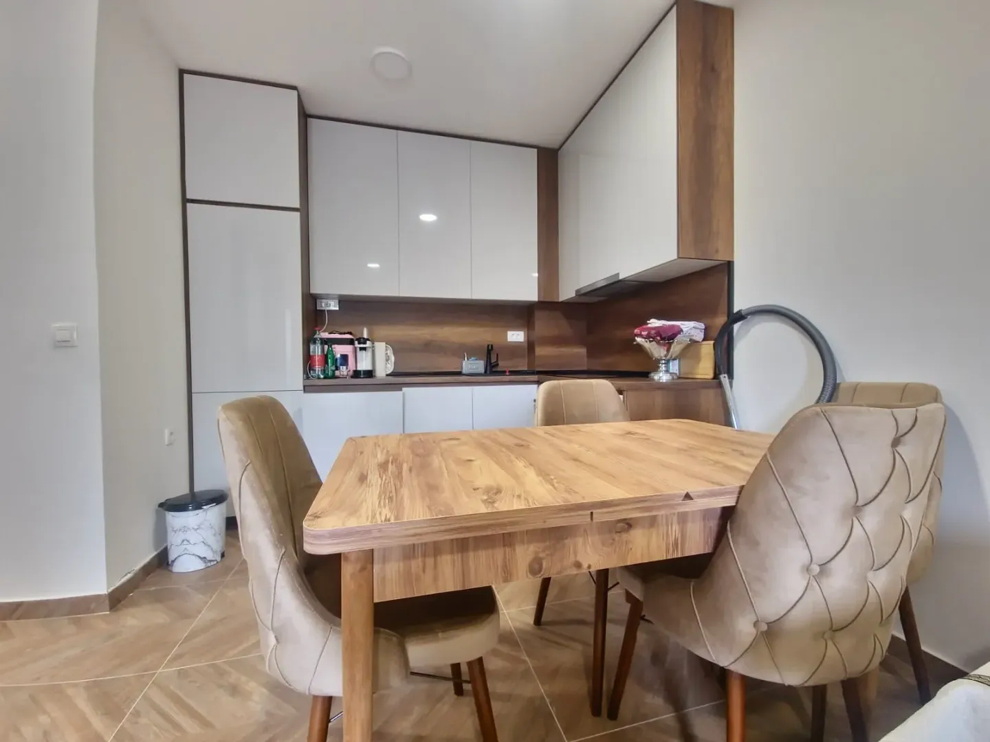 Modern kitchen with a dining table and upholstered chairs.