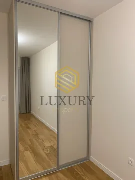 Bedroom with a built-in wardrobe featuring a mirror. - image 6