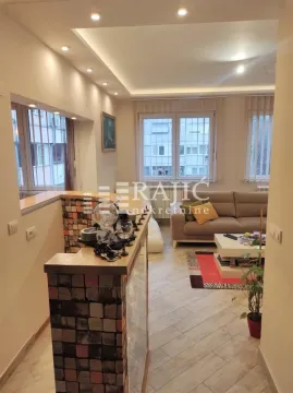 Living room with a sofa and a bar counter in the apartment. - image 5