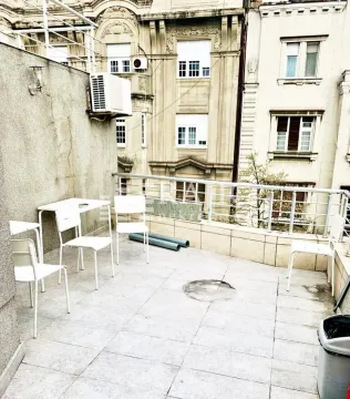 Spacious terrace with patio furniture and a view of surrounding buildings. - image 3