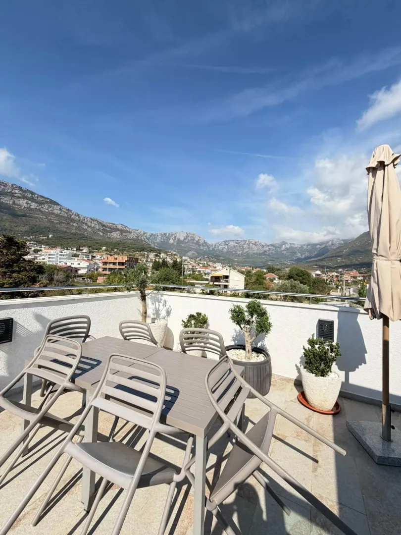 Spacious rooftop terrace with outdoor seating and mountain views.