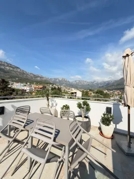 Spacious rooftop terrace with outdoor seating and mountain views. - image 8