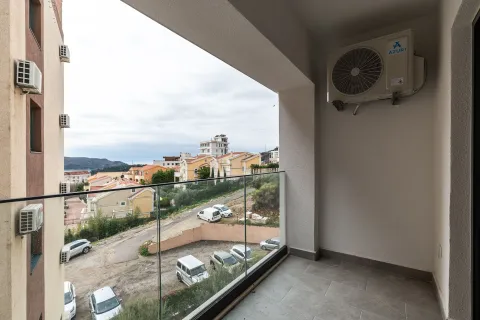 Natkriveni balkon sa staklenom ogradom i pogledom na naselje i parking. - image 8