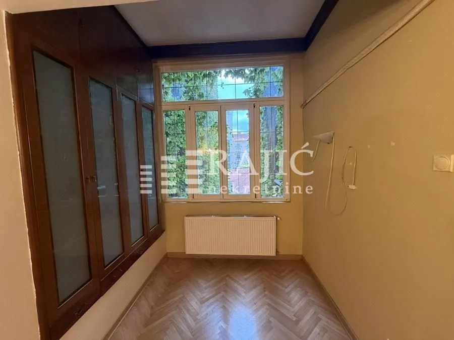 Small room with a large built-in closet, parquet flooring, and a window.