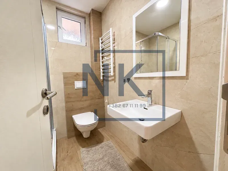 Savremeno opremljeno kupatilo sa tuš kabinom, umivaonikom i WC šoljom.