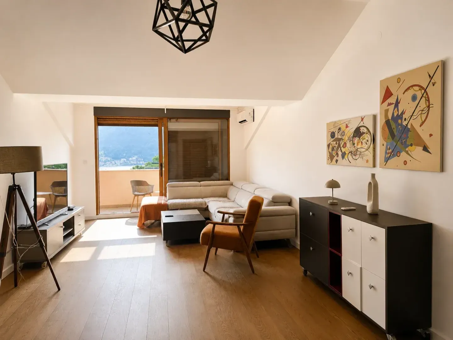 Spacious living room with a sofa, TV, and access to a terrace with a sea view.