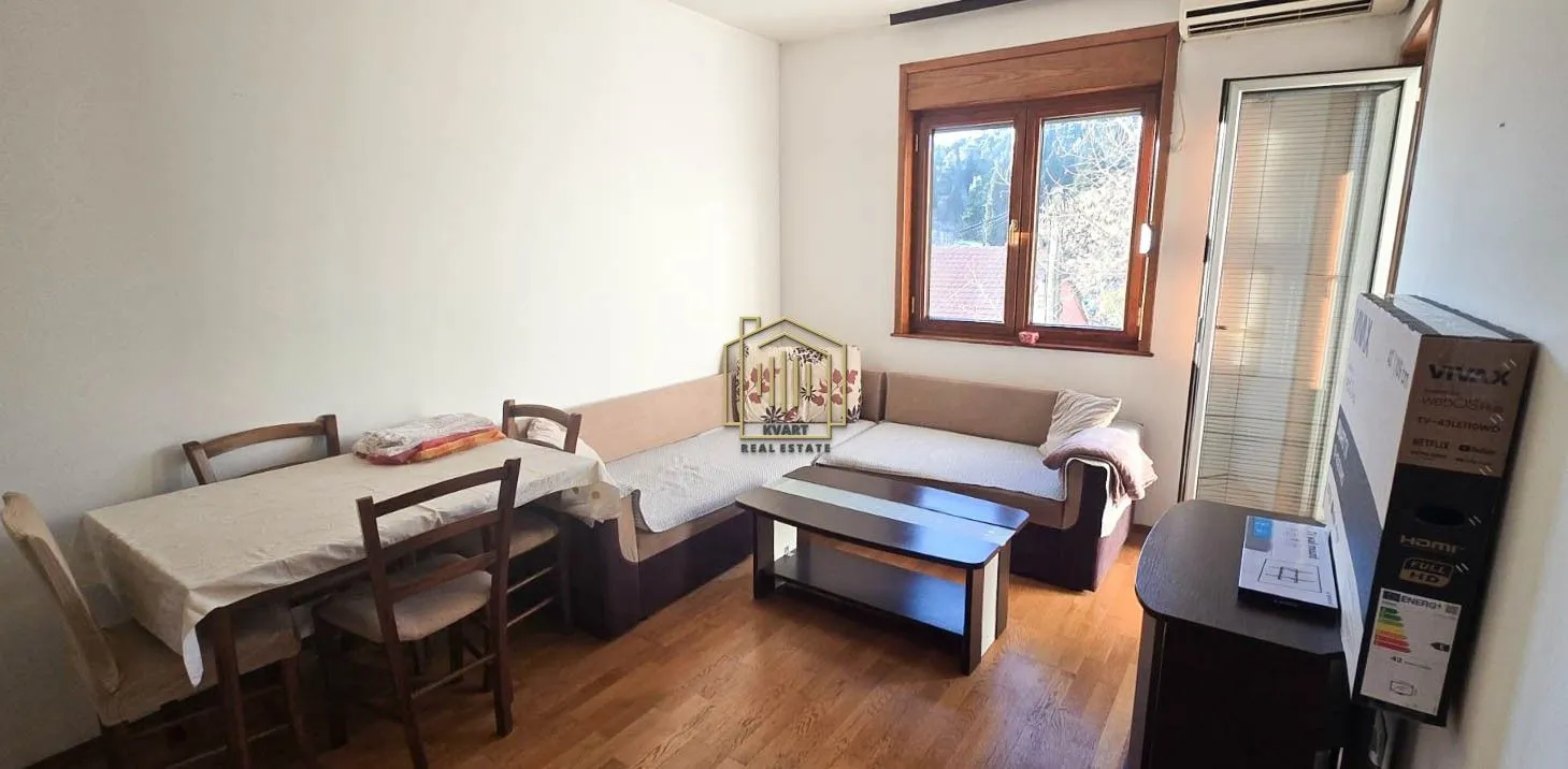 Living room with a sofa set, dining table, and a window.