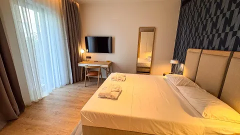 Moderna spavaća soba sa bračnim krevetom, radnim stolom i televizorom. - image 13