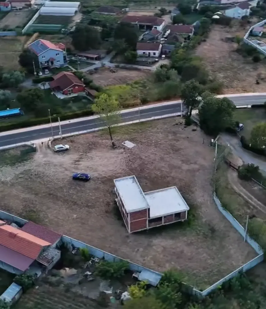 Pogled iz vazduha na plac sa kućom u izgradnji i okruženjem.