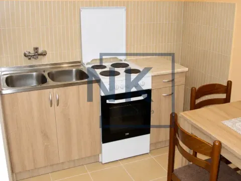Smaller kitchen with a sink, stove, and dining table. - image 6