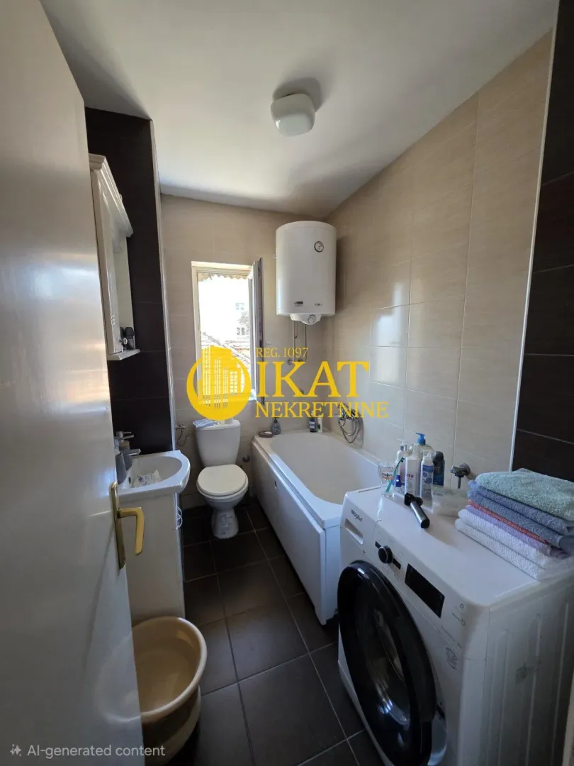 Kupatilo opremljeno kadom, umivaonikom, WC šoljom i veš mašinom.