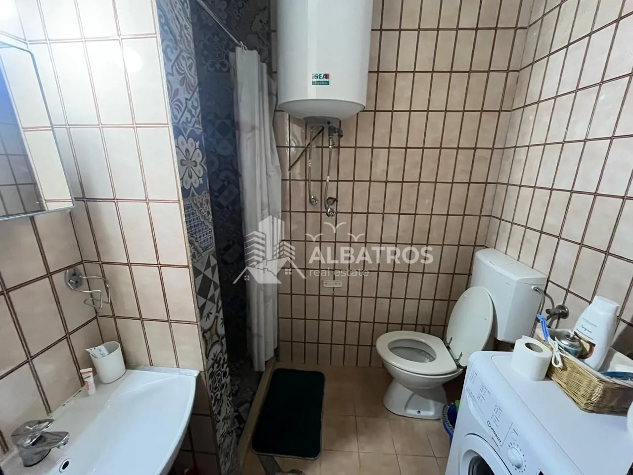 Manje kupatilo sa tuš kabinom, WC šoljom, lavaboom i bojlerom.