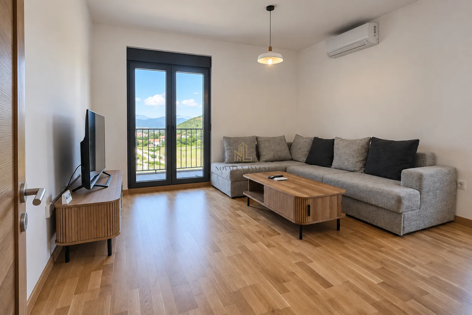 Living room with a sectional sofa, TV, and access to the terrace.