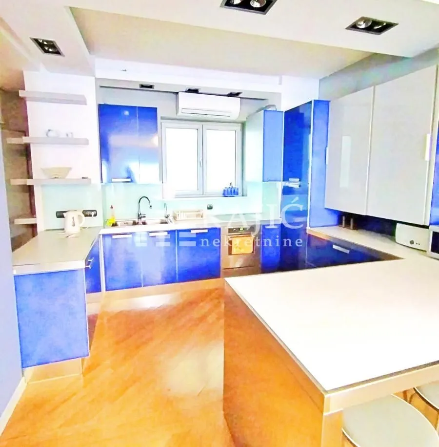 Modern kitchen with blue elements and a breakfast bar.