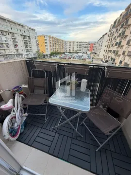 Namješten balkon sa stolom, stolicama i pogledom na naselje. - image 2