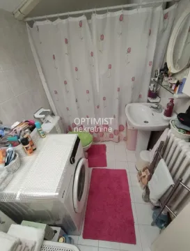 Kupatilo opremljeno umivaonikom, veš mašinom i kadom sa zavesom. - image 19