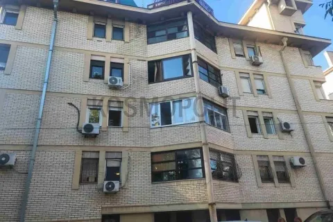 Pogled na fasadu stambene zgrade od cigle sa više prozora i klima uređaja. - image 10