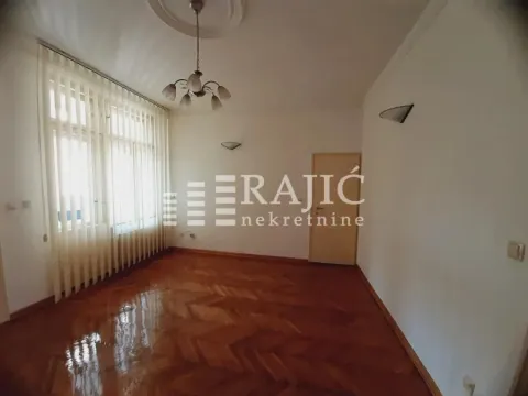 Empty room with parquet flooring and a large window. - image 3