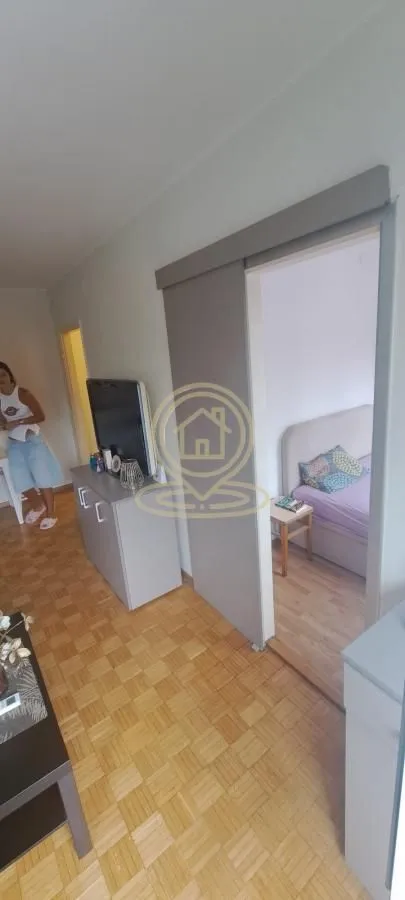 Dnevna soba sa pogledom na spavaću sobu i drvenim podom.