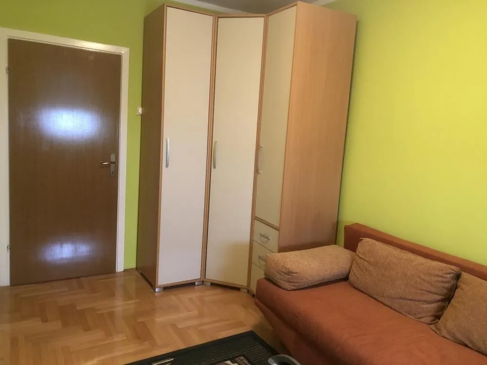 Smaller bedroom with a pull-out sofa and a wardrobe.